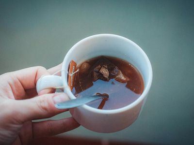 Hands holding a warm cup of herbal tea